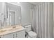 Cozy bathroom featuring a vanity with a cream colored sink, toilet and striped shower curtain at 10753 Seaview Ln, Indianapolis, IN 46236