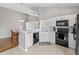 Corner view of kitchen with white cabinets, black appliances, and a marble countertop at 10753 Seaview Ln, Indianapolis, IN 46236