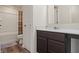 A bathroom featuring a white vanity with quartz countertop, wood-look floors, and a shower-tub combo at 10811 Wild Orchard Ln, Indianapolis, IN 46239