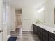 A bathroom showcasing double vanity sinks, modern lighting, and wood-look vinyl flooring at 10811 Wild Orchard Ln, Indianapolis, IN 46239