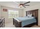 A bedroom with neutral paint, large window, and a king bed with blue bedding and dark wood trim at 10811 Wild Orchard Ln, Indianapolis, IN 46239