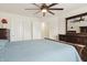 A bedroom with neutral paint, ceiling fan, and a king bed with blue bedding and dark wood trim at 10811 Wild Orchard Ln, Indianapolis, IN 46239