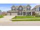Beautiful two-story home with a well-manicured lawn and three-car garage on a sunny day at 10811 Wild Orchard Ln, Indianapolis, IN 46239