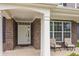 Inviting front porch with seating area, brick accents, and a bright white front door at 10811 Wild Orchard Ln, Indianapolis, IN 46239