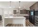Modern kitchen with an island, stainless steel appliances, and stylish dark wood cabinetry at 10811 Wild Orchard Ln, Indianapolis, IN 46239