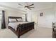 A spacious main bedroom features a leather bed frame, ceiling fan, and ensuite bathroom access at 10811 Wild Orchard Ln, Indianapolis, IN 46239