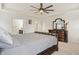 A spacious main bedroom features a leather bed frame, ceiling fan, and dark wood dresser at 10811 Wild Orchard Ln, Indianapolis, IN 46239