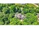 Aerial view of luxury house with stone exterior, surrounded by lush landscaping and mature trees at 11557 Willow Springs Dr, Zionsville, IN 46077