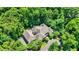 Aerial view of grand house with stone exterior, a large driveway, and surrounded by mature trees at 11557 Willow Springs Dr, Zionsville, IN 46077