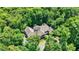 Aerial view of grand house with stone exterior, a large driveway, and surrounded by mature trees at 11557 Willow Springs Dr, Zionsville, IN 46077