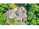 Aerial view of luxury house with stone exterior, patio, mature landscaping, and winding driveway at 11557 Willow Springs Dr, Zionsville, IN 46077