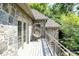 Private balcony view with natural fiber egg chair, stone siding and lush greenery at 11557 Willow Springs Dr, Zionsville, IN 46077
