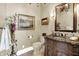 Elegant half bathroom featuring a decorative vanity with a granite countertop and ornate mirror at 11557 Willow Springs Dr, Zionsville, IN 46077