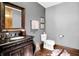 Elegant powder room with a dark wood vanity, framed mirror, and decorative accents at 11557 Willow Springs Dr, Zionsville, IN 46077