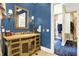 Elegant bathroom features a vanity with a gold framed mirror and a peek into the spacious walk in closet at 11557 Willow Springs Dr, Zionsville, IN 46077