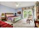 Light and airy bedroom with an elegant bed, carpeted floors, and private balcony access at 11557 Willow Springs Dr, Zionsville, IN 46077