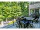 Outdoor deck with metal table, chairs, and wooded view at 11557 Willow Springs Dr, Zionsville, IN 46077