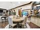 A round table with upholstered chairs sits in the dining room, adjacent to the kitchen with granite counters at 11557 Willow Springs Dr, Zionsville, IN 46077