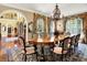 Open dining room features hardwood floors, chandelier lighting, and luxury furnishing at 11557 Willow Springs Dr, Zionsville, IN 46077