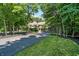 Long paved driveway surrounded by mature trees leading up to an elegant stone home at 11557 Willow Springs Dr, Zionsville, IN 46077