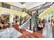 Grand two-story foyer with curved staircase, hardwood floors, and elegant decor at 11557 Willow Springs Dr, Zionsville, IN 46077