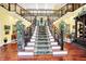 Elegant two-story foyer with a grand staircase, hardwood floors, and decorative railings at 11557 Willow Springs Dr, Zionsville, IN 46077
