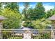 Secluded view of front yard and driveway with lush, green trees and landscaping, as seen from the wrought iron balcony at 11557 Willow Springs Dr, Zionsville, IN 46077