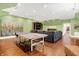 A spacious game room features hard wood floors, a ping pong table and plenty of seating space at 11557 Willow Springs Dr, Zionsville, IN 46077