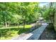 Stone walkway leads to an outdoor kitchen, ideal for entertaining and nestled in the scenic, tree-lined backyard at 11557 Willow Springs Dr, Zionsville, IN 46077