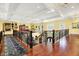 Elegant hallway with hardwood floors, ornate railing, and stunning chandelier lighting the grand two story foyer at 11557 Willow Springs Dr, Zionsville, IN 46077