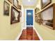 Hallway with wood floors, yellow walls, and elegant framed art at 11557 Willow Springs Dr, Zionsville, IN 46077