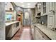 A long runner rug emphasizes the length of this granite and tile kitchen with modern stainless appliances at 11557 Willow Springs Dr, Zionsville, IN 46077