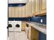 Well-lit laundry room with washer, dryer, and plenty of cabinet and counter space for organization and folding at 11557 Willow Springs Dr, Zionsville, IN 46077