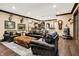 This roomy living room is furnished with leather sofas and ottomans over a patterned rug and dark hardwood floors at 11557 Willow Springs Dr, Zionsville, IN 46077