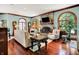 Cozy living room featuring a stone fireplace, hardwood floors, arched windows, and comfortable seating at 11557 Willow Springs Dr, Zionsville, IN 46077