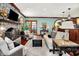 Well-lit living room features a stone fireplace, hardwood floors, comfortable seating, and bright windows at 11557 Willow Springs Dr, Zionsville, IN 46077