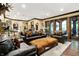The living room is furnished with leather sofas and chairs set on a patterned rug under recessed lighting at 11557 Willow Springs Dr, Zionsville, IN 46077
