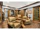 Elegant home office with wood floors, custom built-ins, and comfortable leather chairs at 11557 Willow Springs Dr, Zionsville, IN 46077