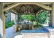 Covered outdoor kitchen has bar, sink, grill, lighting and forest views, ideal for outdoor gatherings and culinary enjoyment at 11557 Willow Springs Dr, Zionsville, IN 46077