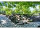 Stone path to a small waterfall and lush landscaping creating a serene outdoor setting at 11557 Willow Springs Dr, Zionsville, IN 46077