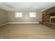 Bright basement with two windows, neutral carpeting, and a brick fireplace at 1217 S Post Rd, Indianapolis, IN 46239