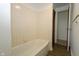Clean bathroom featuring a tub, tiled walls, and a doorway leading to another room at 1217 S Post Rd, Indianapolis, IN 46239