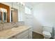 Bright bathroom with vanity, mirror, window, and wood-look floors at 1217 S Post Rd, Indianapolis, IN 46239