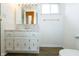 Bathroom with vanity, wood-look floors, and a well-lit mirror and lighting fixture at 1217 S Post Rd, Indianapolis, IN 46239
