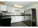 Well-lit kitchen featuring white cabinets, stainless steel refrigerator, and modern appliances at 1217 S Post Rd, Indianapolis, IN 46239