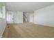 Open living area with neutral carpet, stairs to the upper level, and a view of the front door at 1217 S Post Rd, Indianapolis, IN 46239