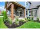 Beautiful covered patio with stone fireplace, seating, and lush landscaping, perfect for entertaining at 12839 Bird Cage, Carmel, IN 46032