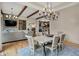 Bright dining room showcasing wood beams, stylish chandelier, hardwood floors, and a view into the kitchen at 12839 Bird Cage, Carmel, IN 46032