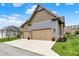 Two car garage with light brown doors and a large driveway at 12839 Bird Cage, Carmel, IN 46032