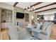 Cozy living room featuring a stone fireplace, wood beams, built-in shelves, and hardwood floors at 12839 Bird Cage, Carmel, IN 46032